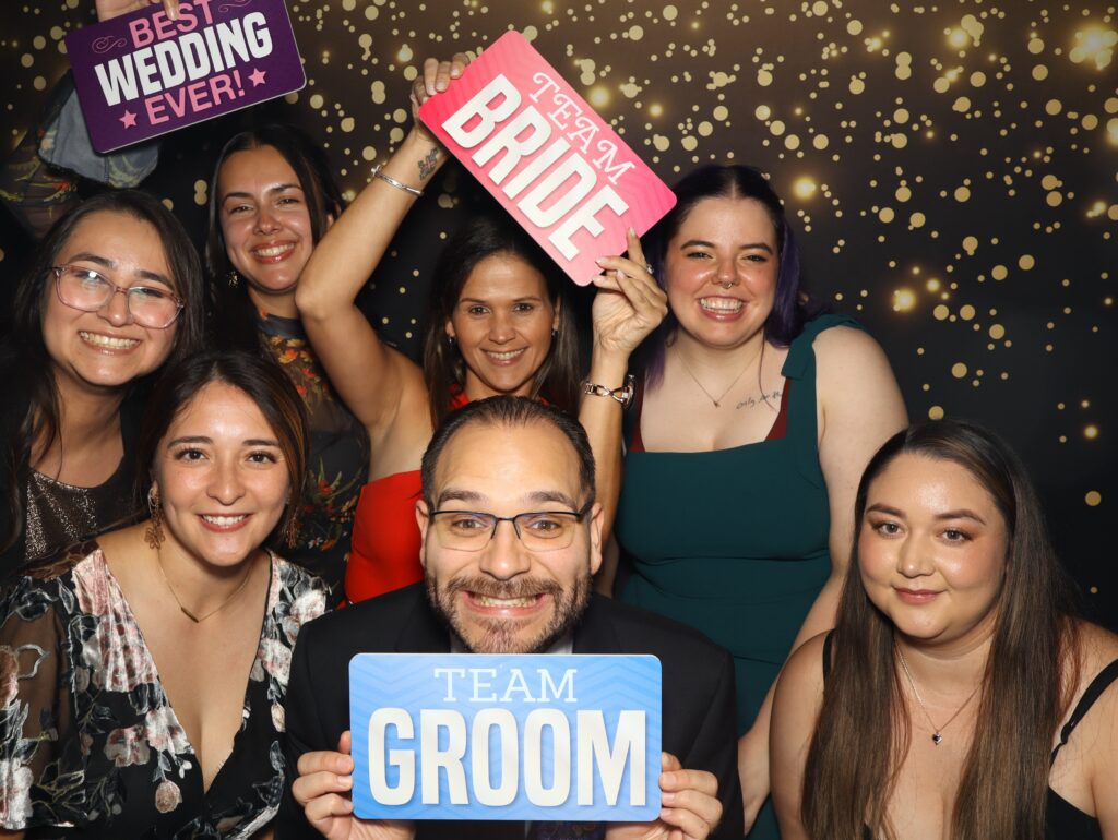 Group of people posing together holding a printed photo card