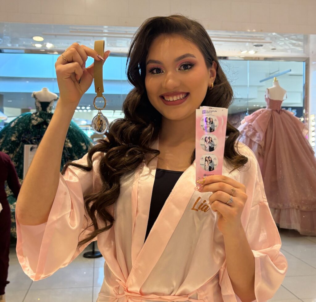 Woman taking a selfie holding up a printed photo keychain