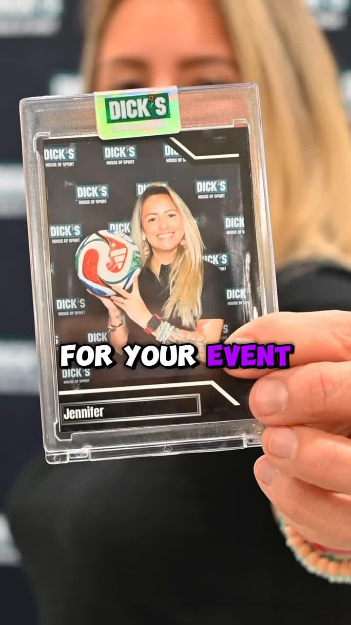 Woman holding up a printed photo booth card, smiling