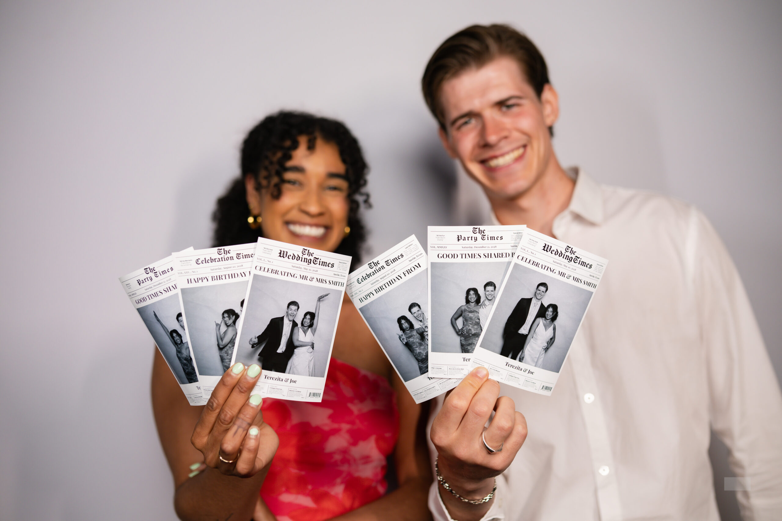 Two people holding up a printed photo card together, smiling