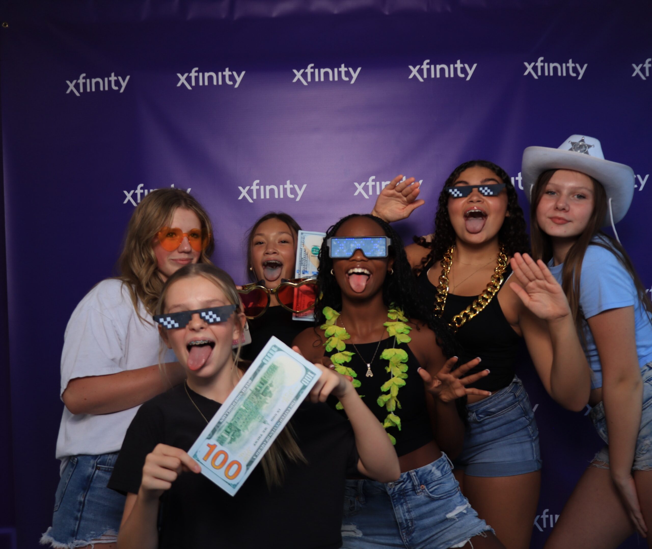 Group of people posing together in front of a dark branded background
