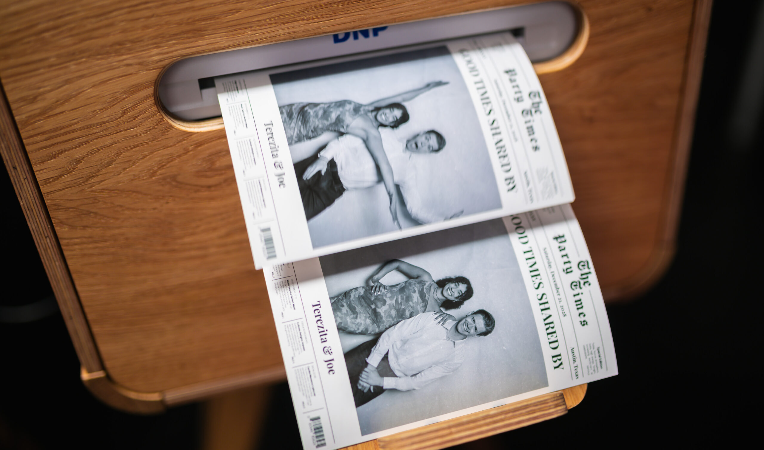 Newspaper-style printed photo booth card on a table