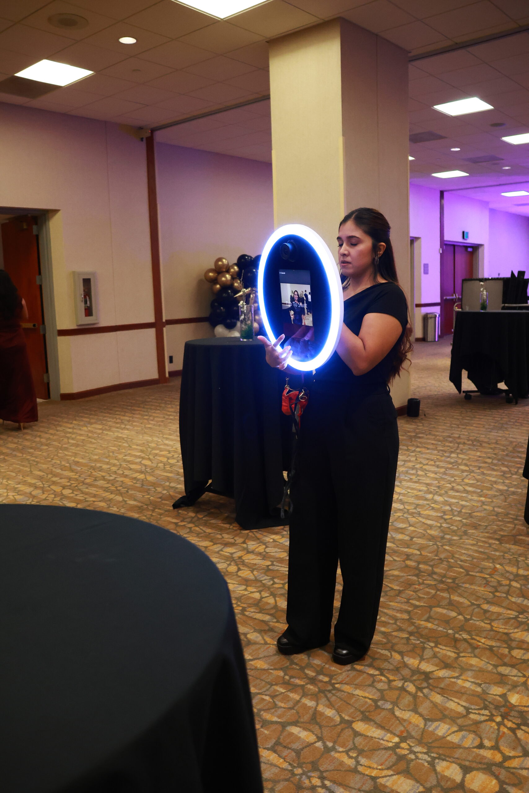 Person posing with a glowing ring light photo booth