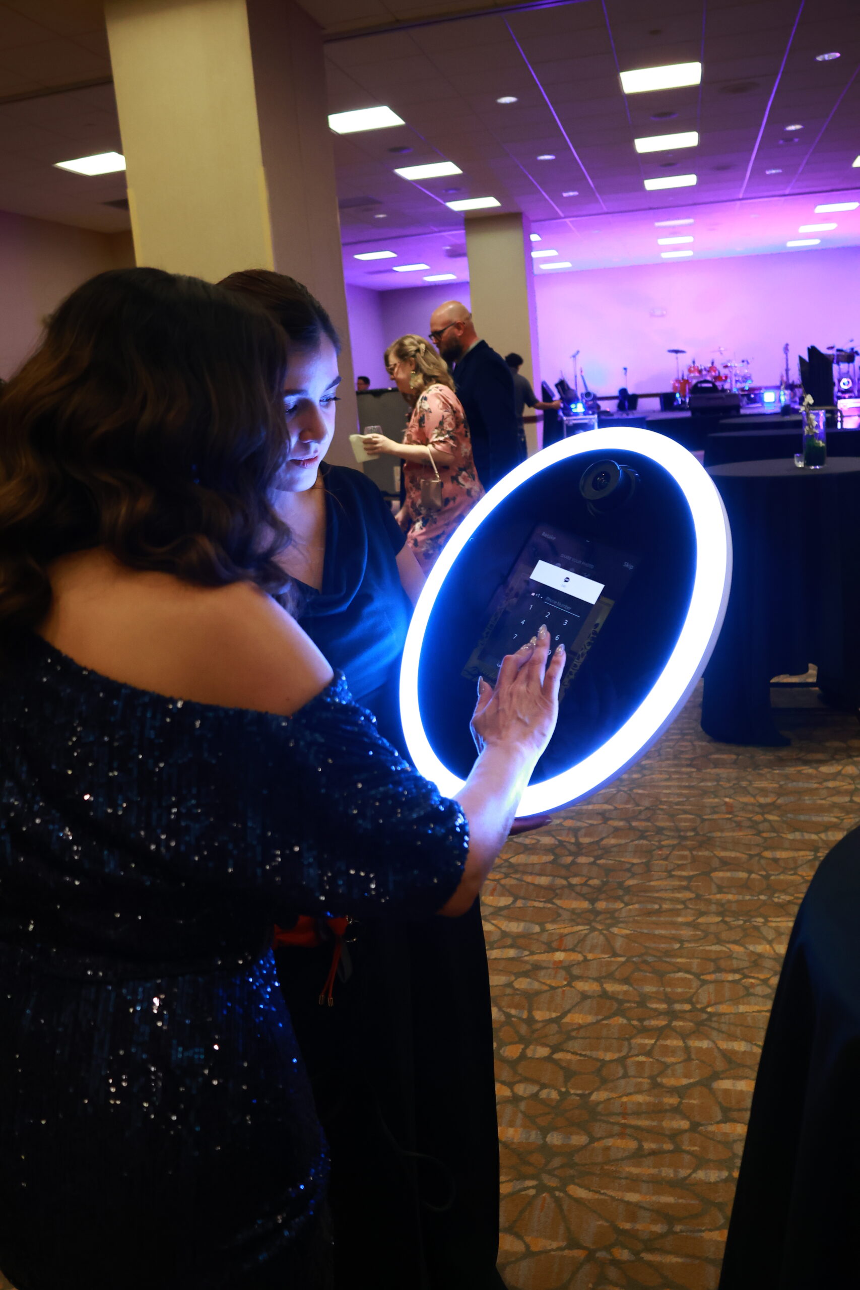 Person posing with a glowing ring light photo booth