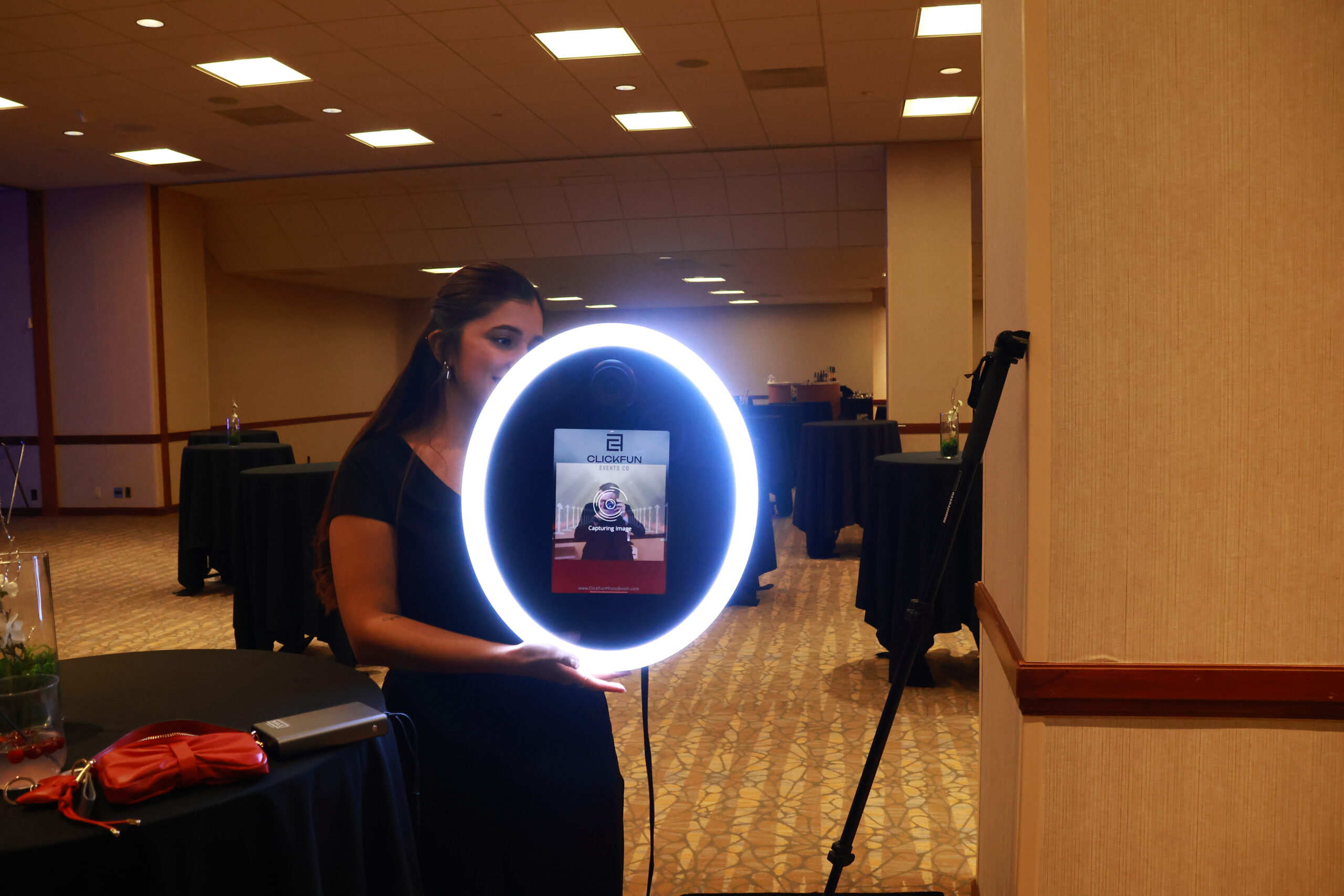 Person posing with a glowing ring light photo booth