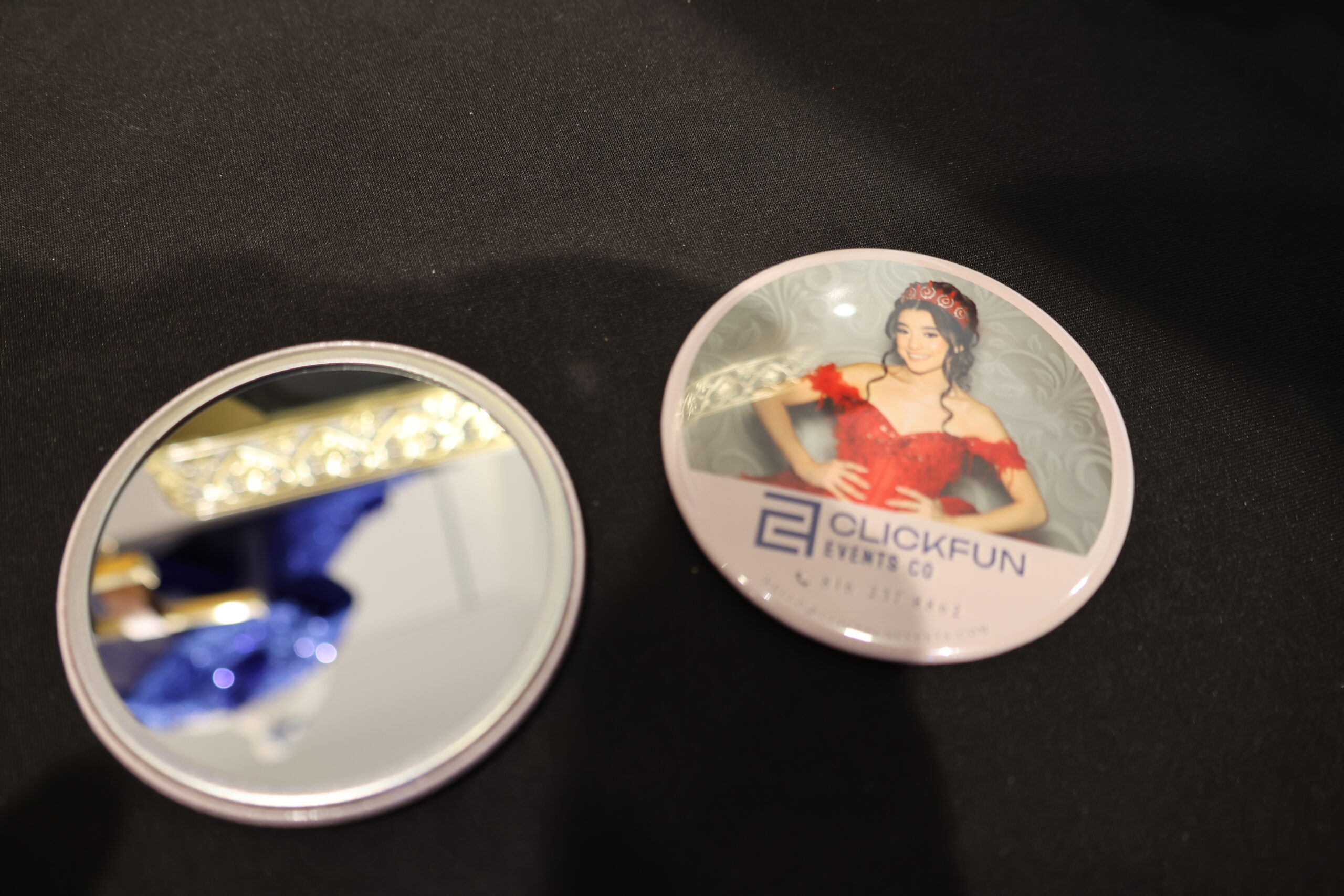 Circular pins/buttons featuring a woman's portrait on a dark surface
