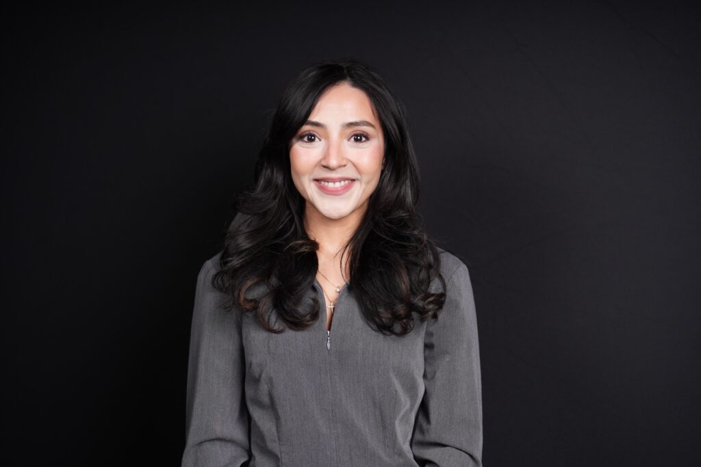 Woman in a grey top smiling for a headshot