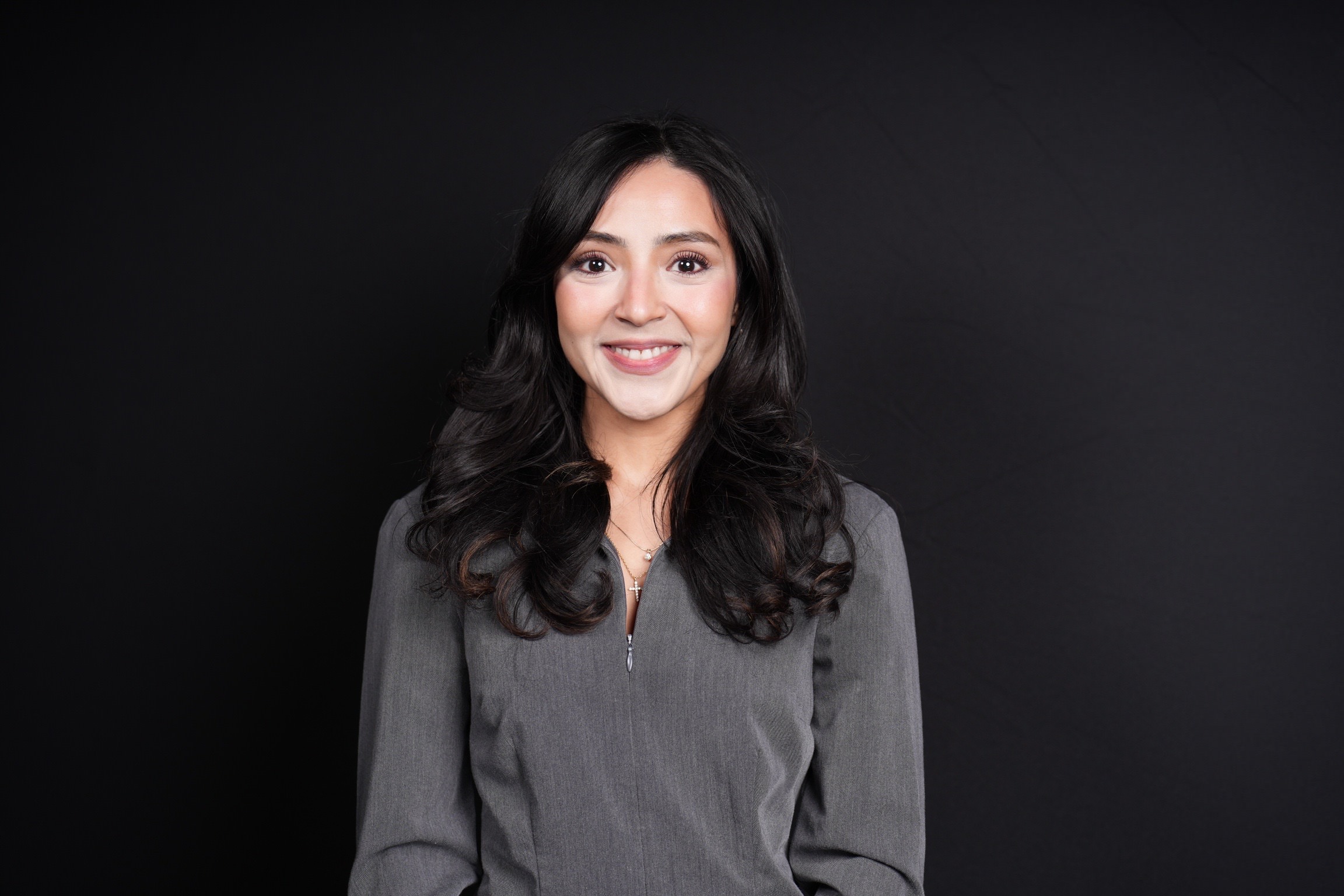 Woman in a grey top smiling for a headshot