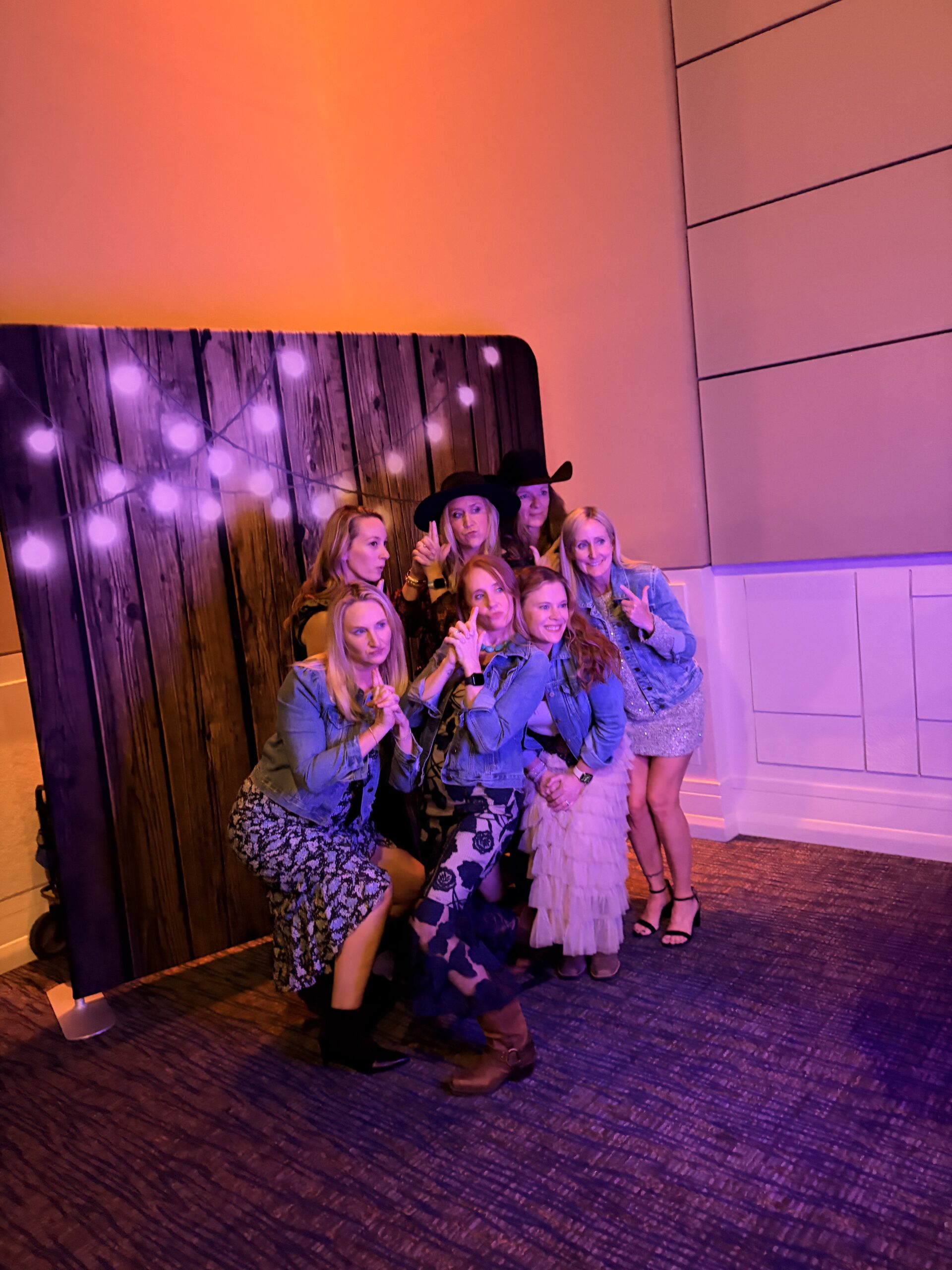 People posing together at an event with colorful lighting