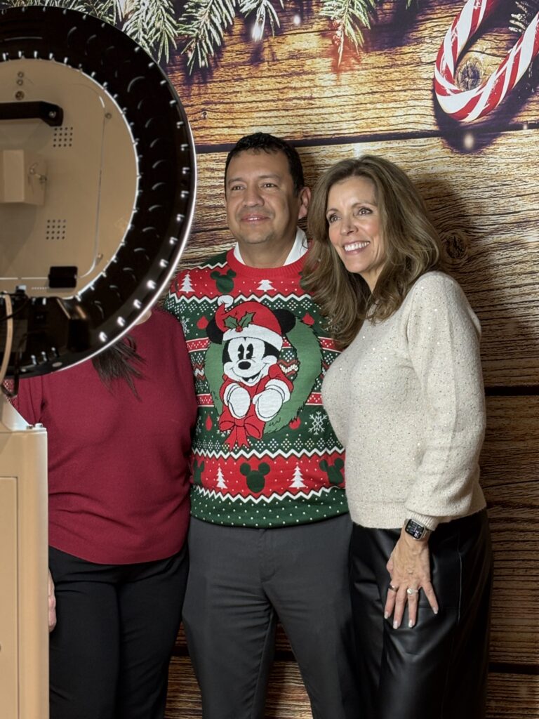 Man and woman posing together against a wooden backdrop