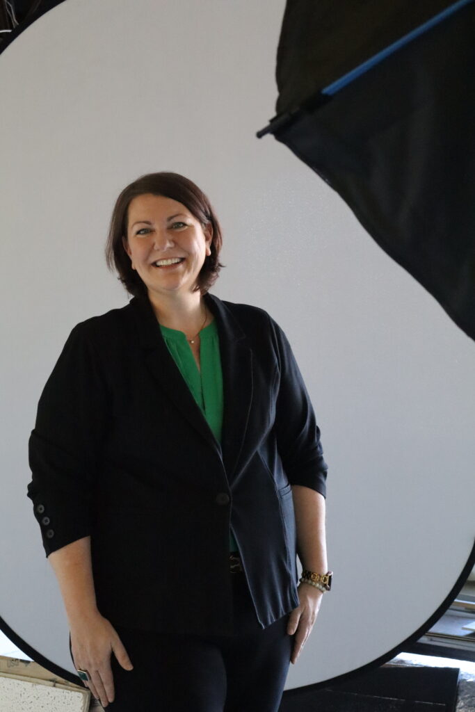 Woman in a green top smiling for a headshot