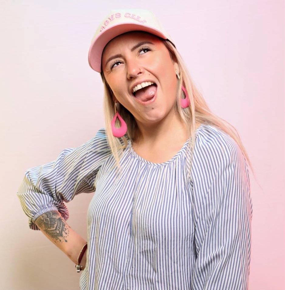 Woman in a pink cap laughing and posing